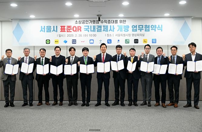 2월 26일 오전 서울시청에서 열린 '서울시 표준QR 국내결제사 개방 업무협약식'에 참석한 오세훈 서울시장(좌측 7번째)이 협약식에 참석한 개방 참여사 대표들과 협약서를 들고 기념촬영을 하고 있다.